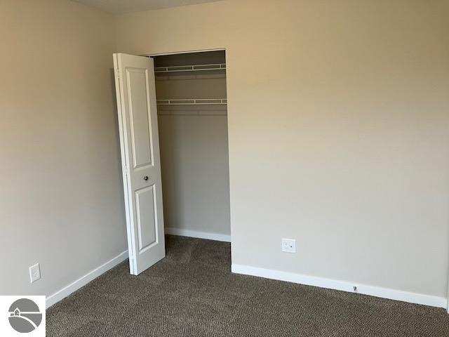 unfurnished bedroom featuring a closet and light colored carpet