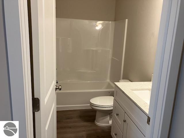 full bathroom with vanity, shower / bathing tub combination, toilet, and hardwood / wood-style flooring