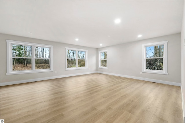 unfurnished room with light wood-type flooring and plenty of natural light