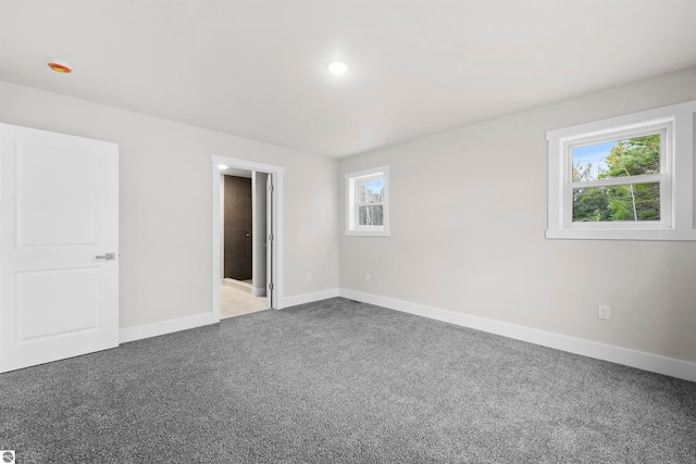 unfurnished bedroom featuring carpet flooring and multiple windows