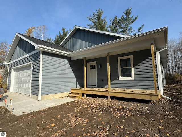 front facade featuring covered porch and a garage