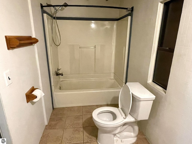 bathroom with toilet, tile patterned floors, and shower / washtub combination