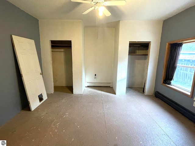 unfurnished bedroom featuring ceiling fan, two closets, and a baseboard heating unit