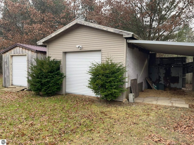 garage with a carport and a lawn