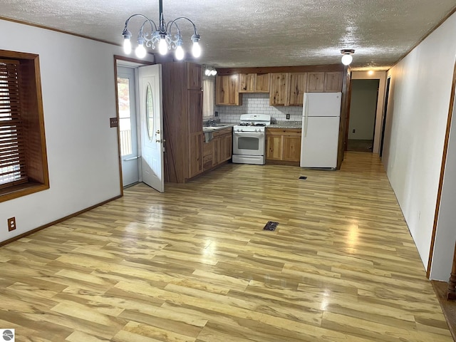 kitchen with tasteful backsplash, a notable chandelier, light hardwood / wood-style floors, decorative light fixtures, and white appliances