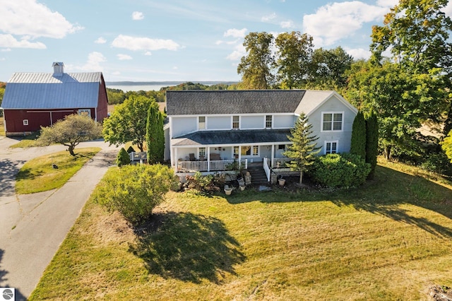 back of house featuring covered porch and a lawn