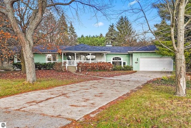 single story home with a front lawn, covered porch, and a garage