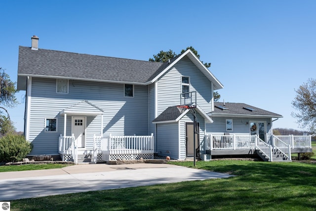 rear view of house with a lawn and a wooden deck