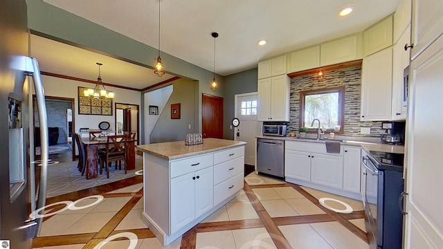 kitchen with a center island, white cabinetry, ornamental molding, and appliances with stainless steel finishes