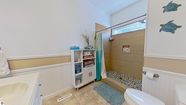 bathroom featuring tile patterned floors, vanity, curtained shower, and toilet