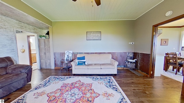 living room featuring dark hardwood / wood-style floors, ceiling fan, wooden walls, and wood ceiling