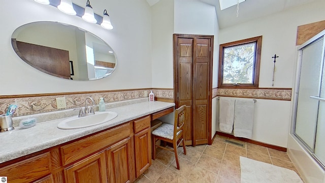 bathroom with tile patterned flooring, vanity, and enclosed tub / shower combo