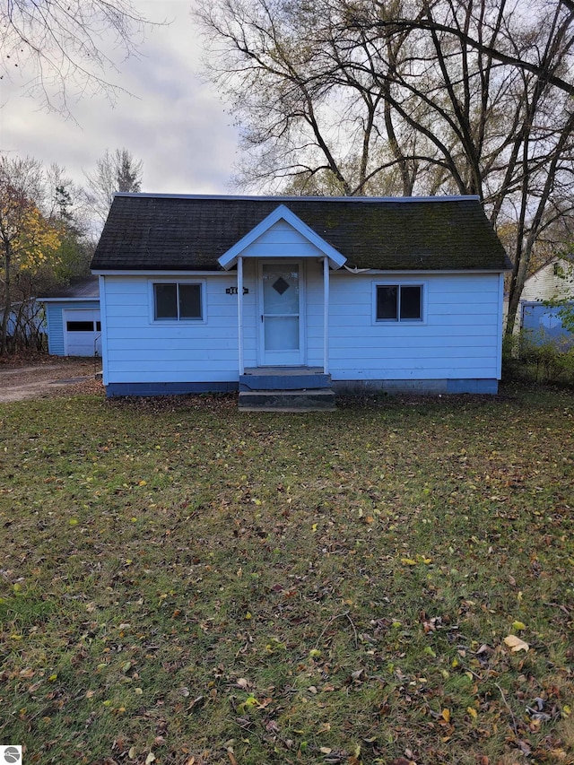 ranch-style house with an outbuilding and a front lawn