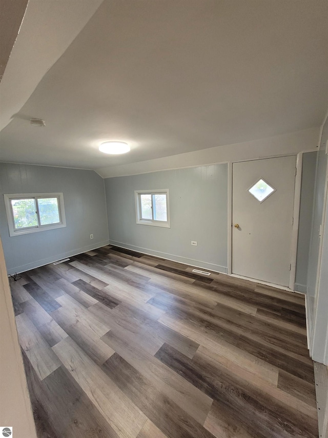 spare room featuring wood-type flooring and lofted ceiling