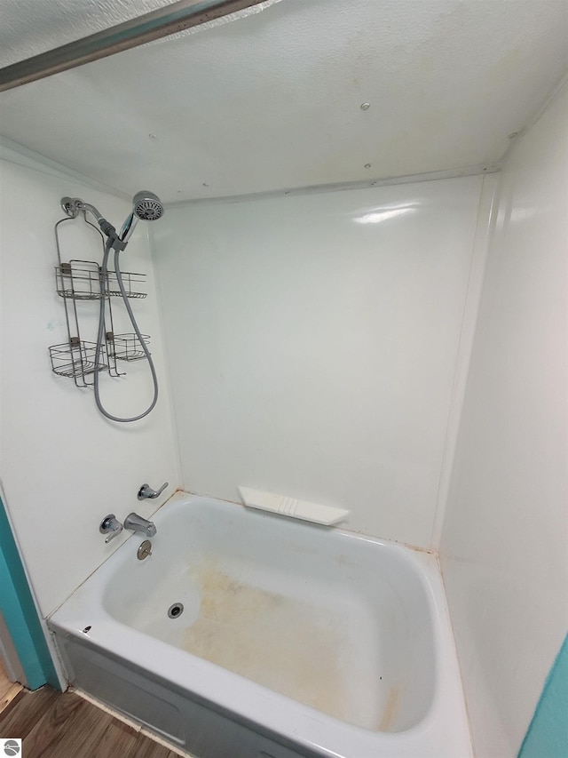 bathroom with wood-type flooring and bathing tub / shower combination