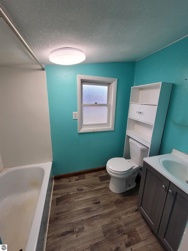 full bathroom featuring tub / shower combination, vanity, a textured ceiling, wood-type flooring, and toilet