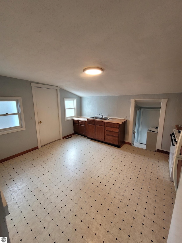 kitchen featuring sink, lofted ceiling, and a textured ceiling