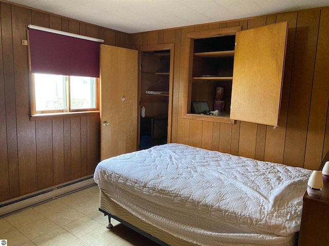 bedroom featuring wood walls and baseboard heating