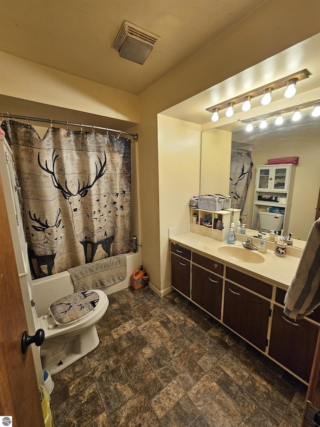9100 E Miller Rd, Durand, MI 48429 - bathroom with vanity, toilet, shower / bath combo, stone finish floors, and baseboards