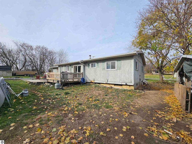 rear view of property featuring fence and a deck