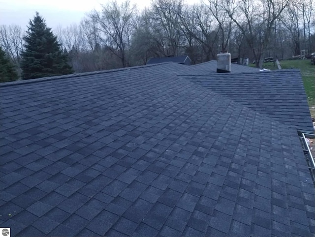 details featuring a chimney and a shingled roof