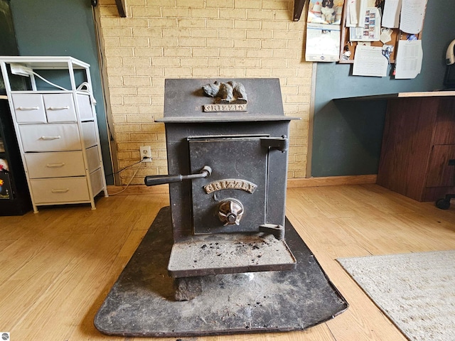 details featuring baseboards, a wood stove, and wood finished floors