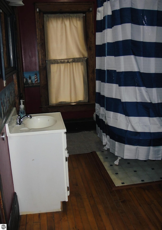 bathroom featuring hardwood / wood-style flooring, vanity, and shower / bath combo with shower curtain