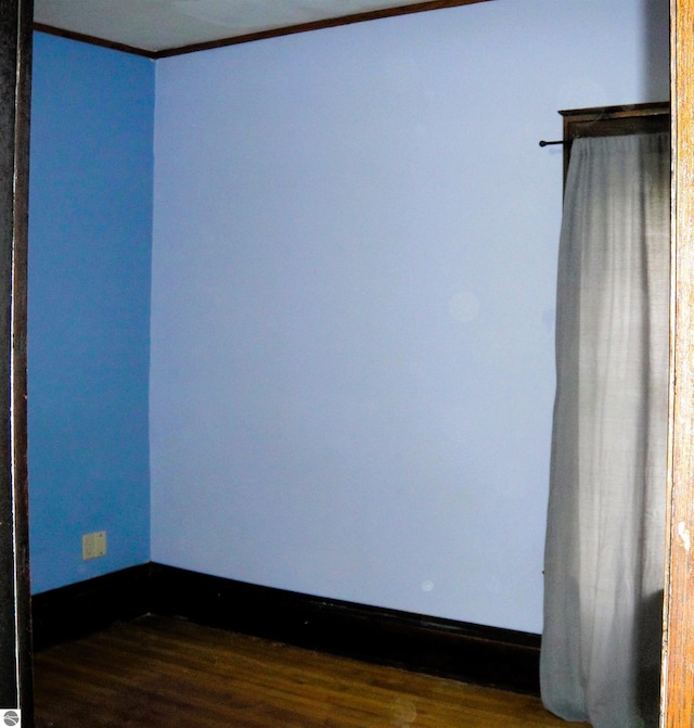 unfurnished room featuring dark hardwood / wood-style flooring and ornamental molding