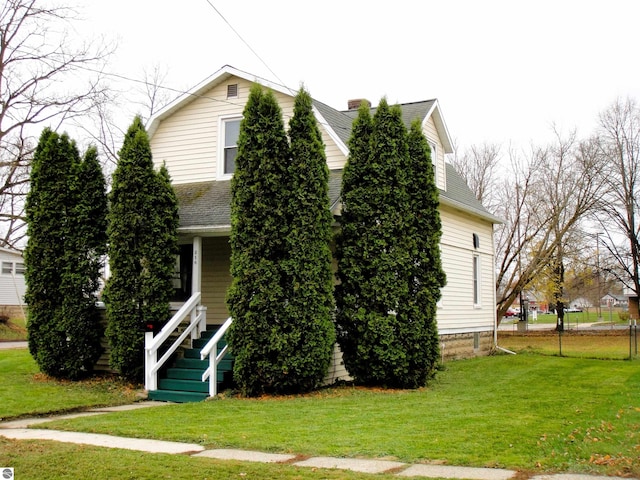 view of property hidden behind natural elements with a front lawn