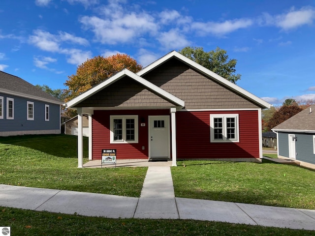 bungalow-style house with a front lawn