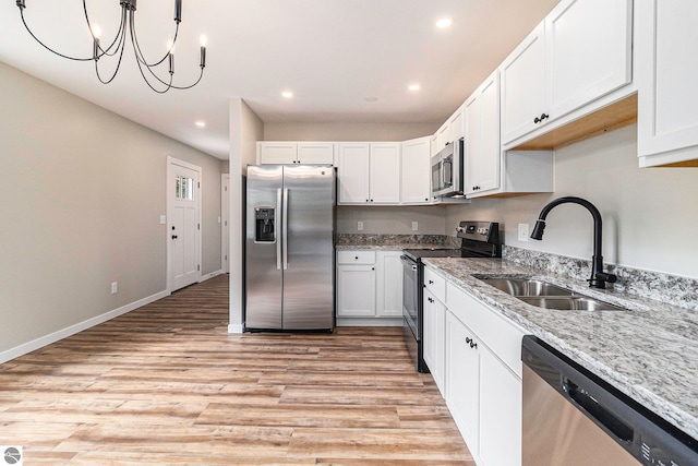 kitchen featuring white cabinets, appliances with stainless steel finishes, light hardwood / wood-style flooring, and sink