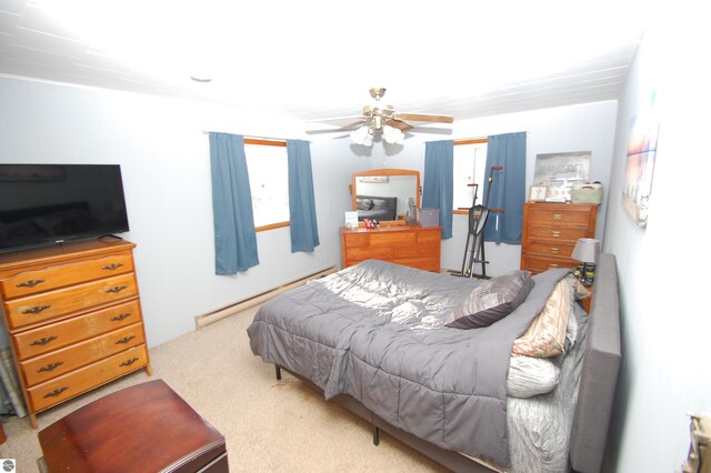 bedroom with baseboard heating, ceiling fan, and carpet floors