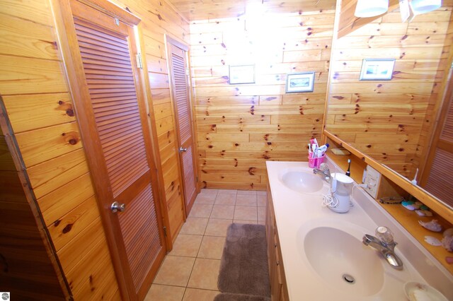 bathroom featuring tile patterned flooring, vanity, and wooden walls