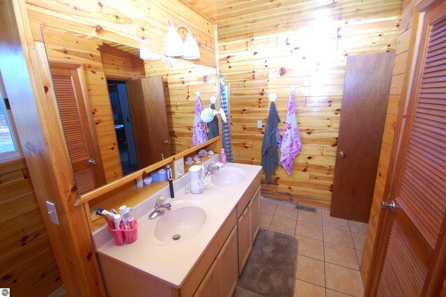 bathroom with tile patterned flooring, vanity, and wood walls