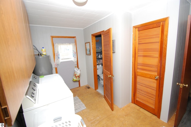 4207 Grass Lake Rd, West Branch, MI 48661 - clothes washing area featuring ornamental molding, water heater, and washer / dryer