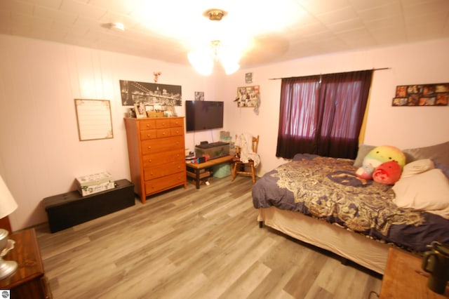 4207 Grass Lake Rd, West Branch, MI 48661 - bedroom with wood finished floors and a chandelier