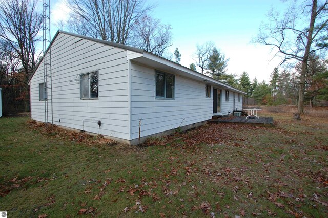 view of side of property with a patio area and a lawn