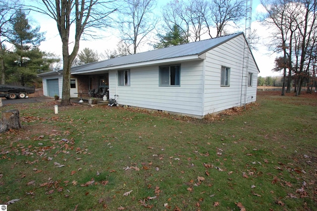 4207 Grass Lake Rd, West Branch, MI 48661 - ranch-style house featuring an attached garage, metal roof, and a front lawn