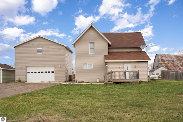 back of house featuring a garage, a deck, and a yard