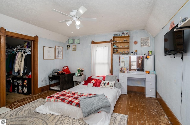 bedroom with ceiling fan, a closet, a textured ceiling, and vaulted ceiling