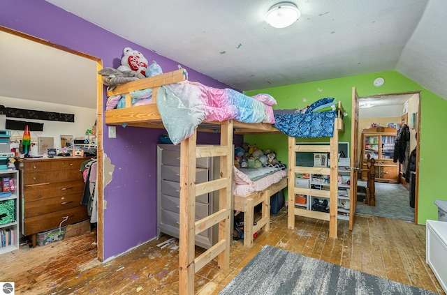 bedroom with hardwood / wood-style floors and lofted ceiling