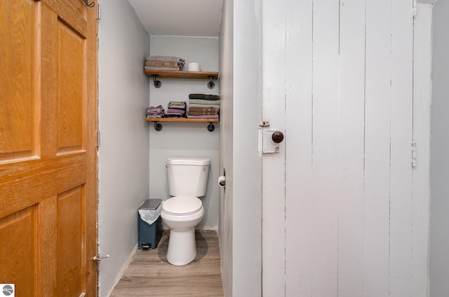 bathroom featuring wood-type flooring and toilet