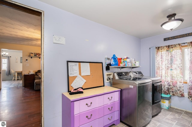 clothes washing area with washing machine and clothes dryer and light hardwood / wood-style floors