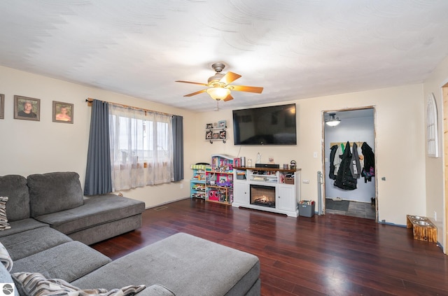 living room with dark hardwood / wood-style flooring and ceiling fan