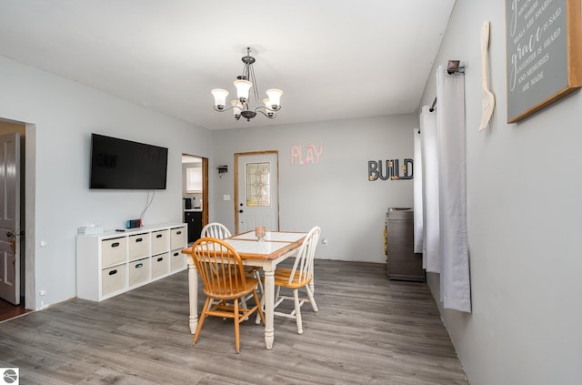 dining room with hardwood / wood-style floors and a chandelier