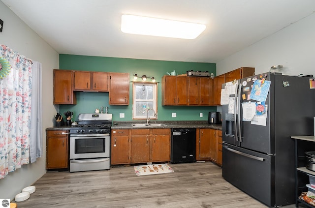 kitchen with sink, stainless steel appliances, and light hardwood / wood-style floors