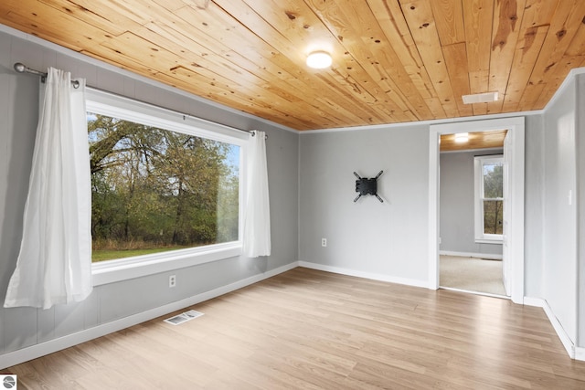 empty room with ornamental molding, wooden ceiling, and light wood-type flooring