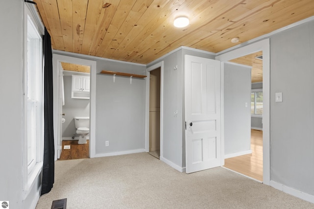 unfurnished bedroom with ensuite bathroom, light colored carpet, and wooden ceiling