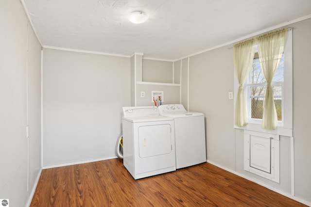 laundry room featuring washer and dryer, wood-type flooring, and ornamental molding