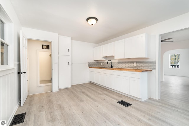 726 Pennsylvania Ave, Alma, MI 48801 - kitchen with white cabinets, light hardwood / wood-style floors, butcher block counters, and sink